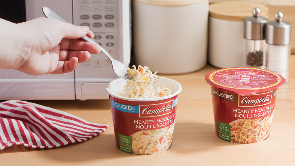 Campbell's hearty noodles beside microwave
